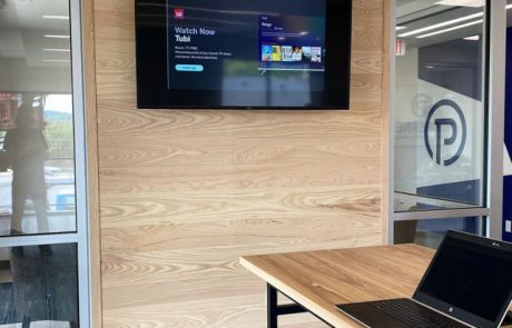 Wood paneled wall with mounted tv in an office setting