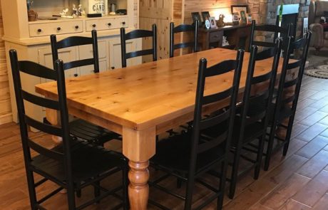 Wooden dining room table surrounded by black chairs