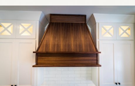 Bright white kitchen with custom wood vent hood