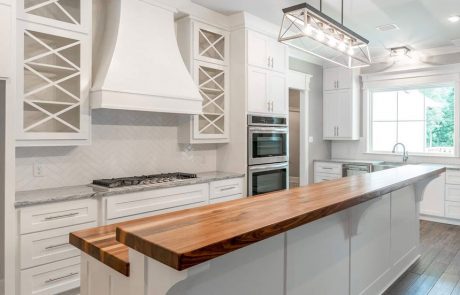 Bright white kitchen with silver accents and custom butcher block countertop