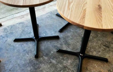 Two person tables with a black stand and wood tops